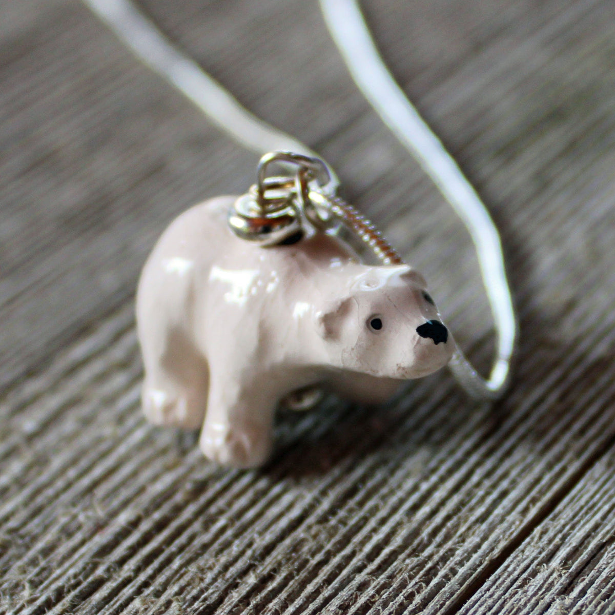 The Hand-Painted Ceramic Polar Bear Necklace—an ideal wildlife animal lover gift—features a ceramic polar bear on a silver chain, offering a unique piece of jewelry for nature enthusiasts.