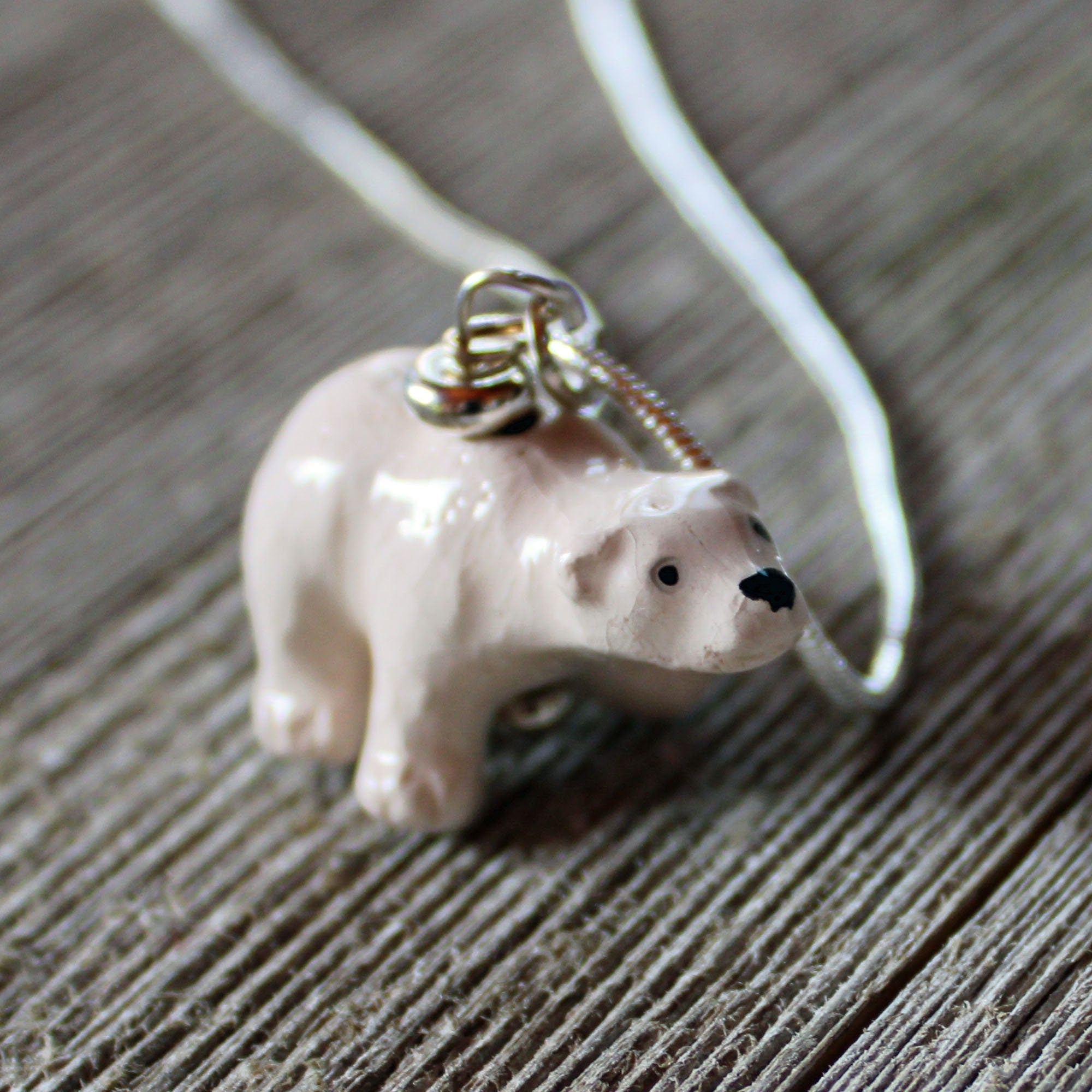 The Hand-Painted Ceramic Polar Bear Necklace—an ideal wildlife animal lover gift—features a ceramic polar bear on a silver chain, offering a unique piece of jewelry for nature enthusiasts.