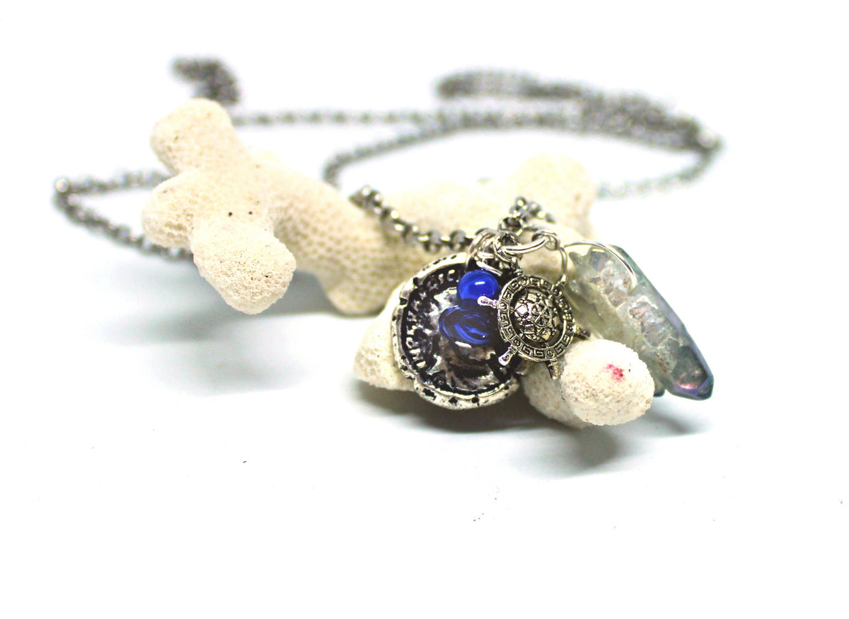 Close-up of the Pirate’s Booty Charm Necklace showcasing shimmering silver, blue gemstones, and intricate nautical charms.