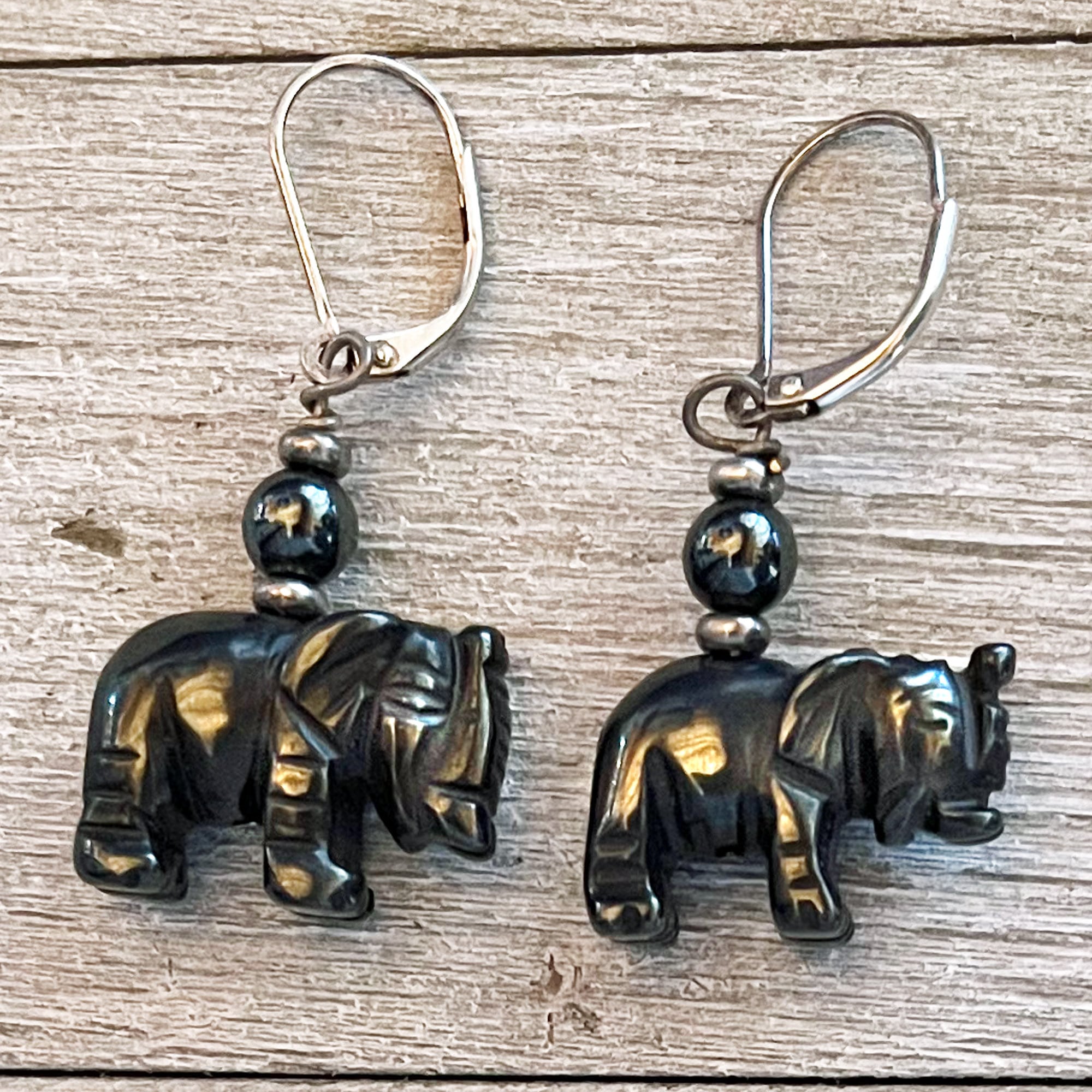 Hematite Elephant Earrings with black carved elephant charms and round black beads, finished with sterling silver lever backs—an elegant piece of spiritual jewelry. Other stones available.