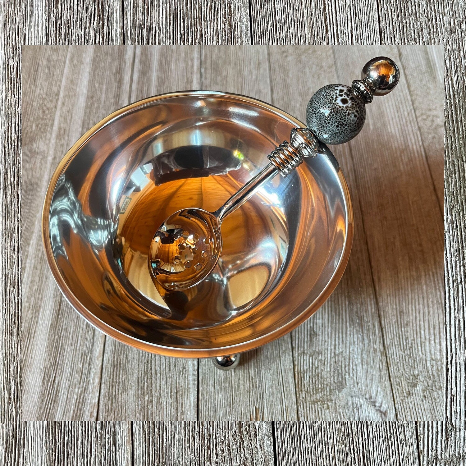 Close-up of the Modern Stainless Steel Bowl Set with Gray Ceramic Legs and Matching Spoon, highlighting the sleek design and elegant finishes.