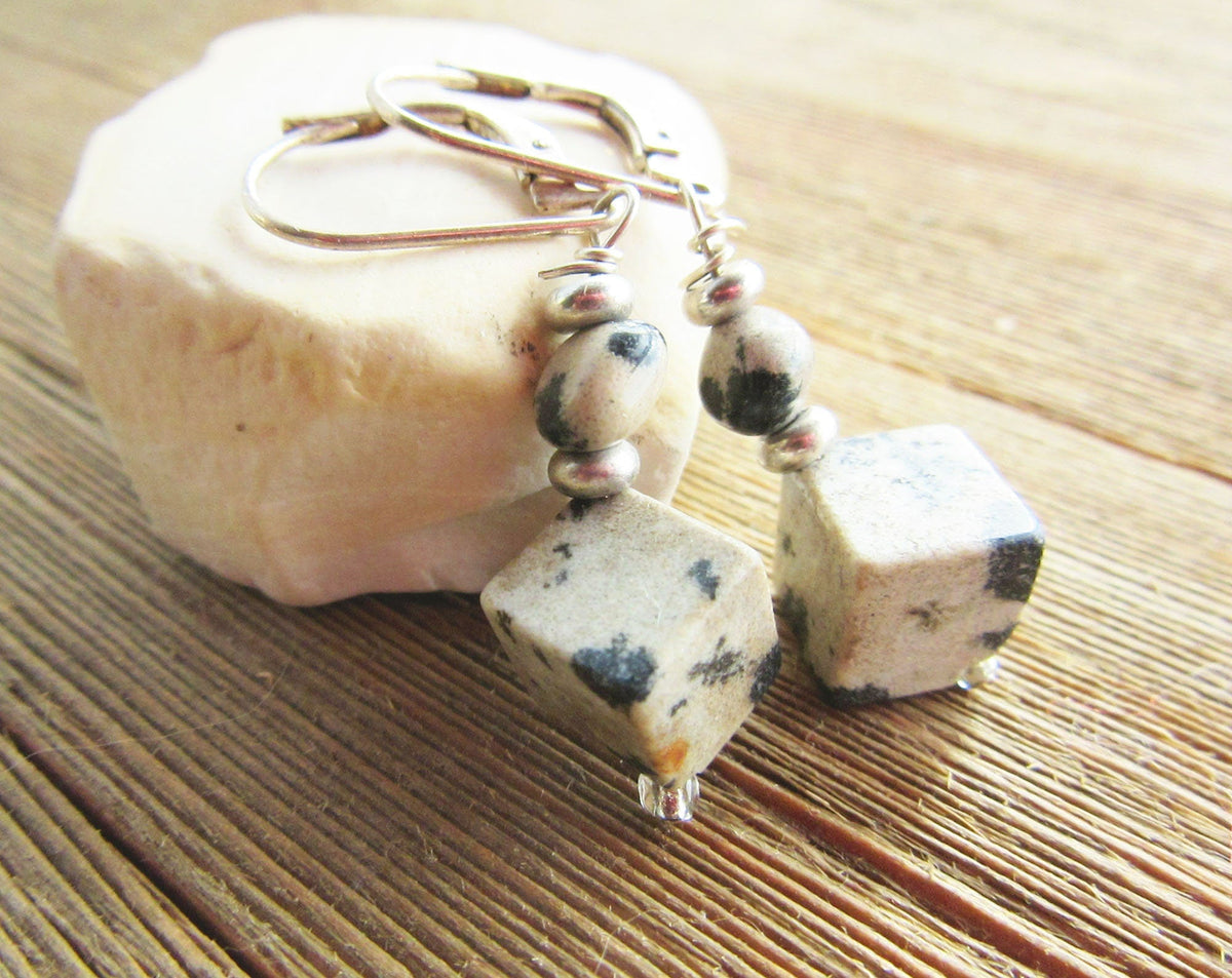 Close-up view of Sacred Geometry Dalmatian Jasper Cube Earrings featuring smooth faceted gemstones and elegant lever back earwires.
