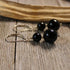 Black Tourmaline Sphere Earrings – Artisan Designed Metaphysical Gemstone Jewelry with silver hooks and two glossy black beads per earring, displayed on rustic wood—perfect for stylish protective energy.