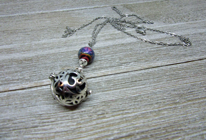 Display of the Namaste Symbol Color Changing Essential Oil Diffusing Zen Chamber Necklace in bright natural lighting, emphasizing its unique color changing property.