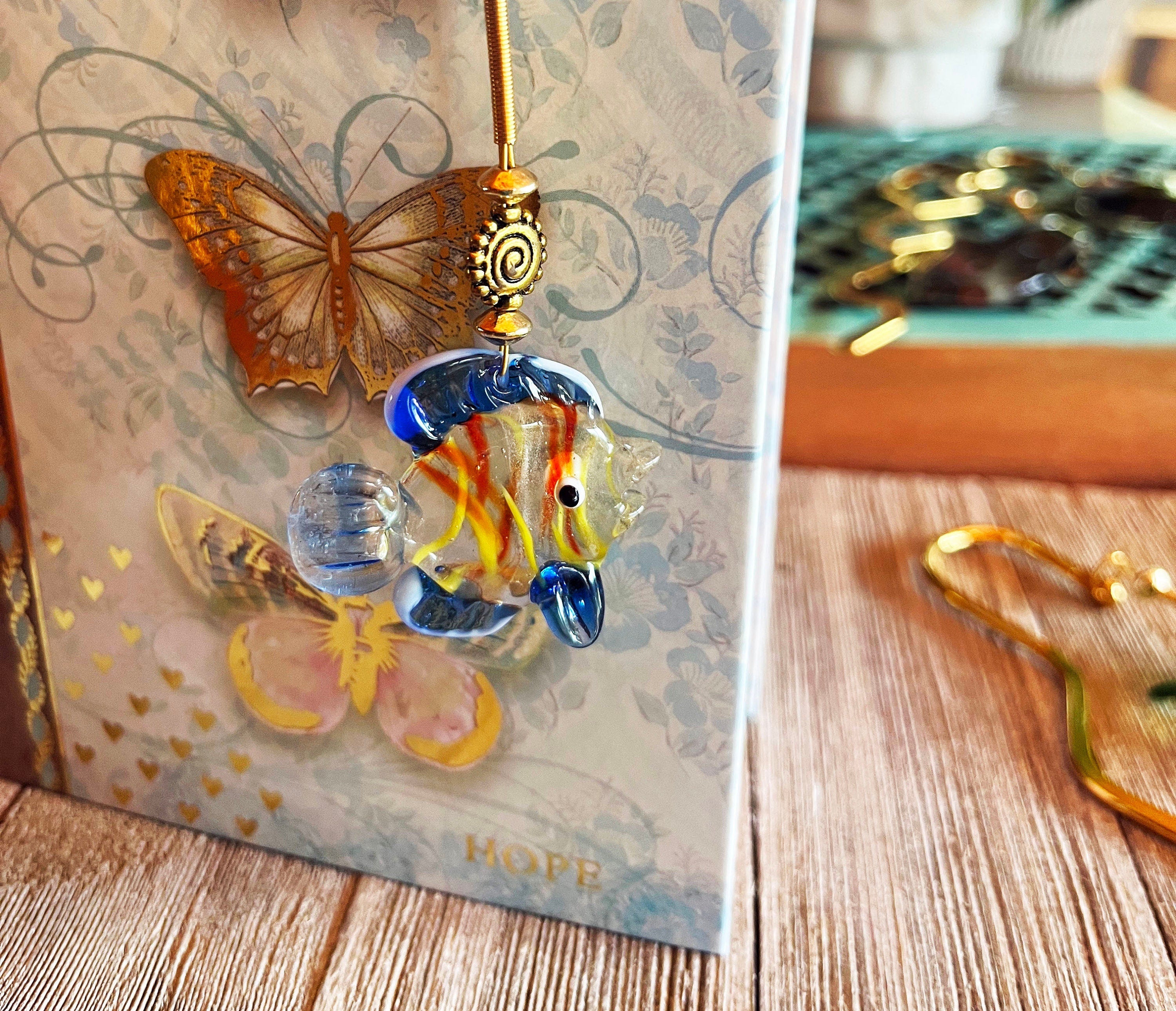 Gold Metal Bookmark featuring a vibrant Glass Fish charm, perfect aquatic page holder gift for aquarists.