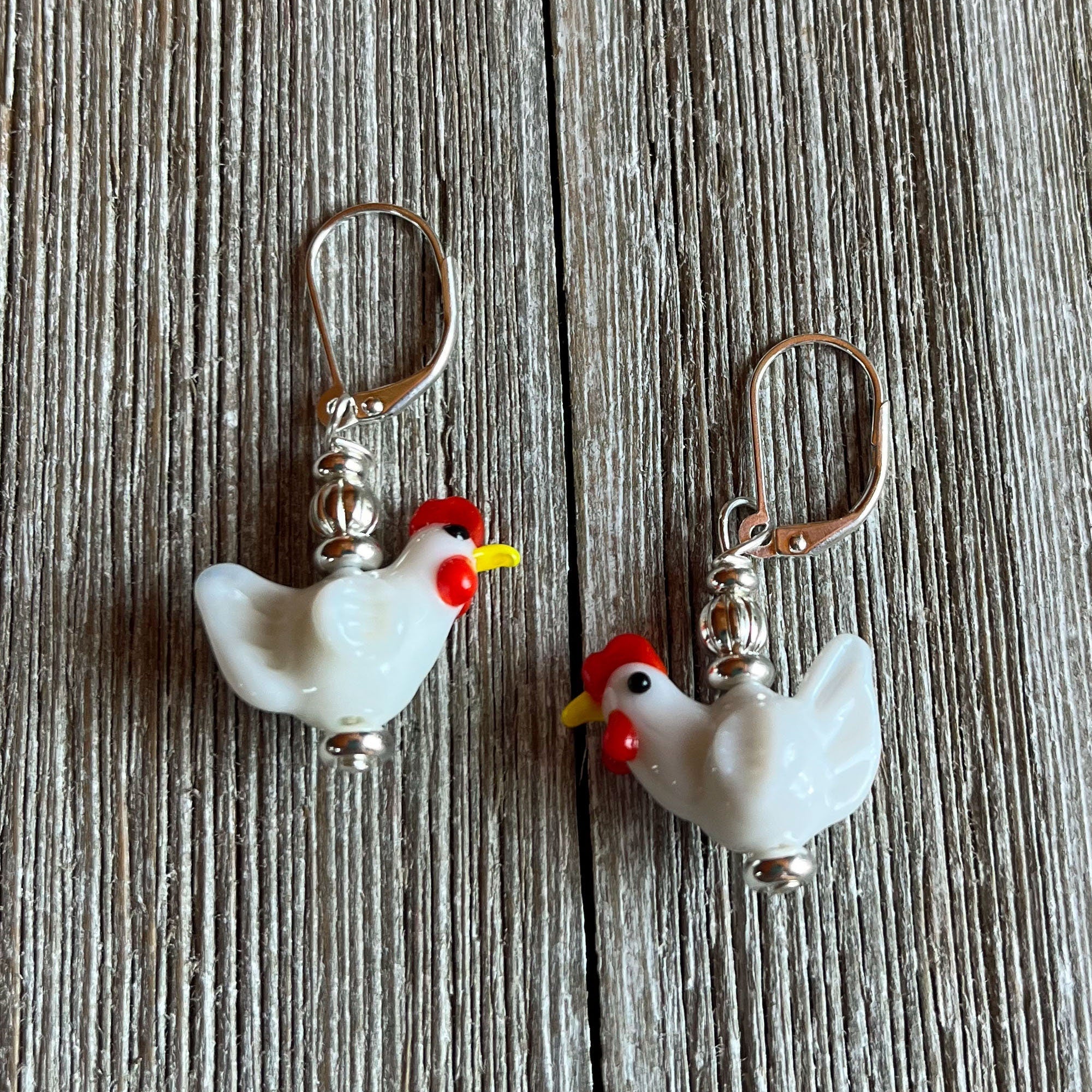 Close-up of the Hen Earrings Gift that is egg strodinary - highlighting unique white lamp work glass chicken design, ideal for chicken lovers and farm enthusiasts.