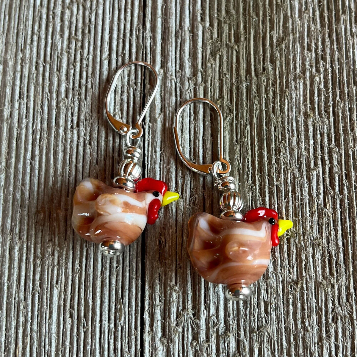 Brown lampwork glass chicken earrings, a unique and egg stra ordinary gift for chicken lovers, inspired by farm aesthetics. Perfect for showcasing your love for hens.