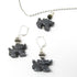 The Handcrafted Hematite Dragon Jewelry Set includes sterling silver earrings, a necklace, and a bangle. Each piece features dark hematite accents and is beautifully displayed on a white background.