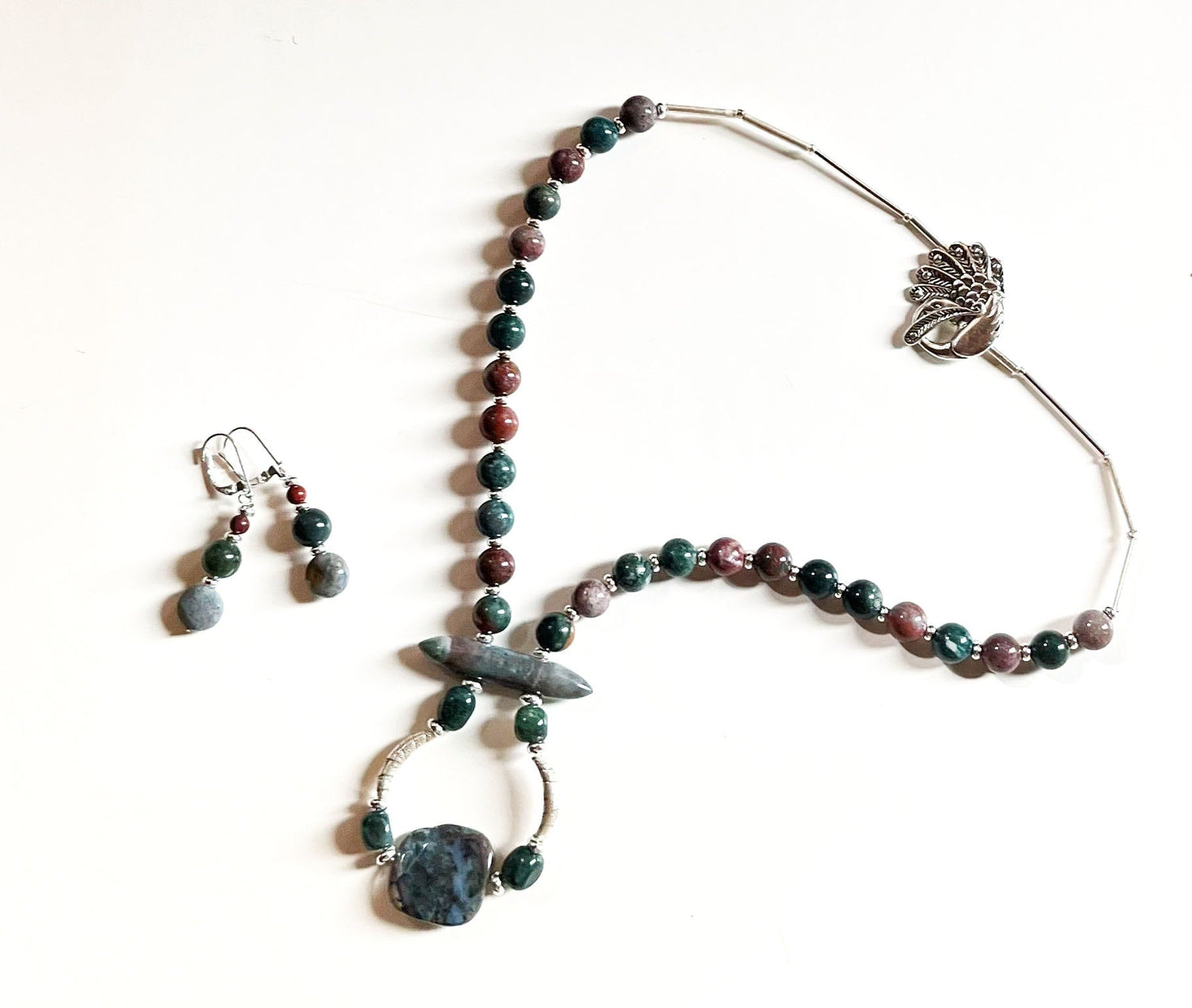 Close-up view of Fancy Peacock Jewelry Set highlighting the soft pastel Fancy Jasper stones and detailed sterling silver peacock clasp.