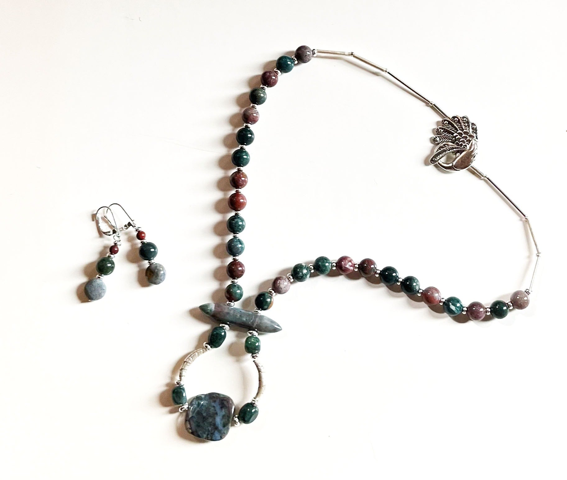 Close-up view of Fancy Peacock Jewelry Set highlighting the soft pastel Fancy Jasper stones and detailed sterling silver peacock clasp.