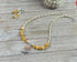 The Sterling Silver Bird Aventurine Necklace Earrings Set from Zen Artisan Jewelry is displayed on a wooden surface with matching earrings, a sea urchin shell, and other artisan pieces.