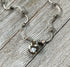 The Ocean Jasper Necklace Set: Artisan Wave Pendant Jewelry for Everyday Serenity by Gwynstone features handcrafted sterling silver with beads and a floral brown glass pendant, displayed on rustic wood.