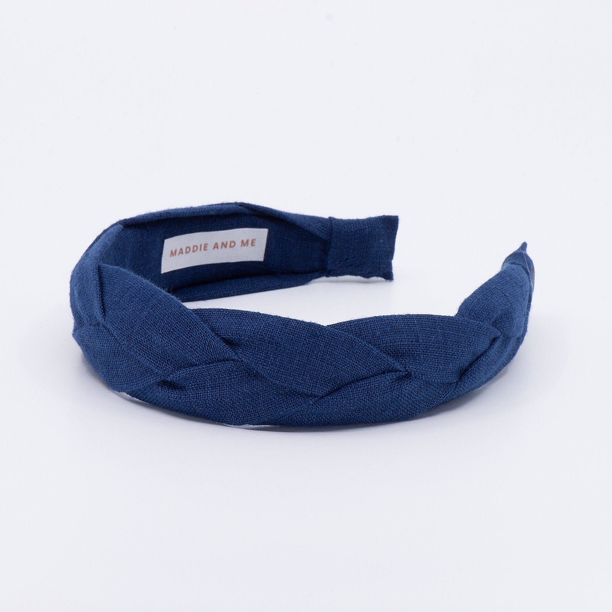 May include: A navy blue braided headband with the text &amp;quot;MADDIE AND ME&amp;quot; on the inside.