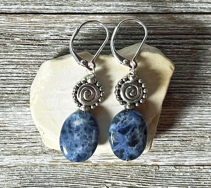 Sodalite earrings - artisan-designed stone and spiral, denim blue earrings. Close-up view highlighting intricate blue swirls and sterling silver accents.