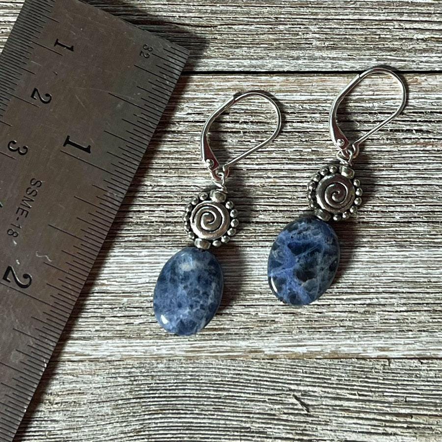 Sodalite earrings - artisan-designed stone and spiral, denim blue earrings. Worn model showing how they elevate a casual outfit, emphasizing creativity and self-expression.