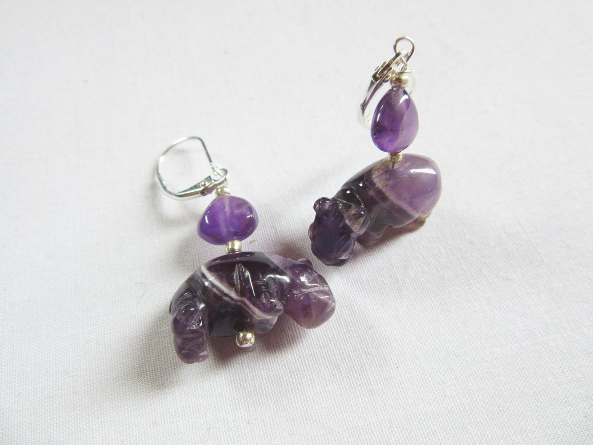 Handcrafted Amethyst Hippo Earrings with Sterling Silver lever backs, featuring carved purple hippos and round amethyst beads—ideal for lovers of unique handmade jewelry and displayed on a white background.