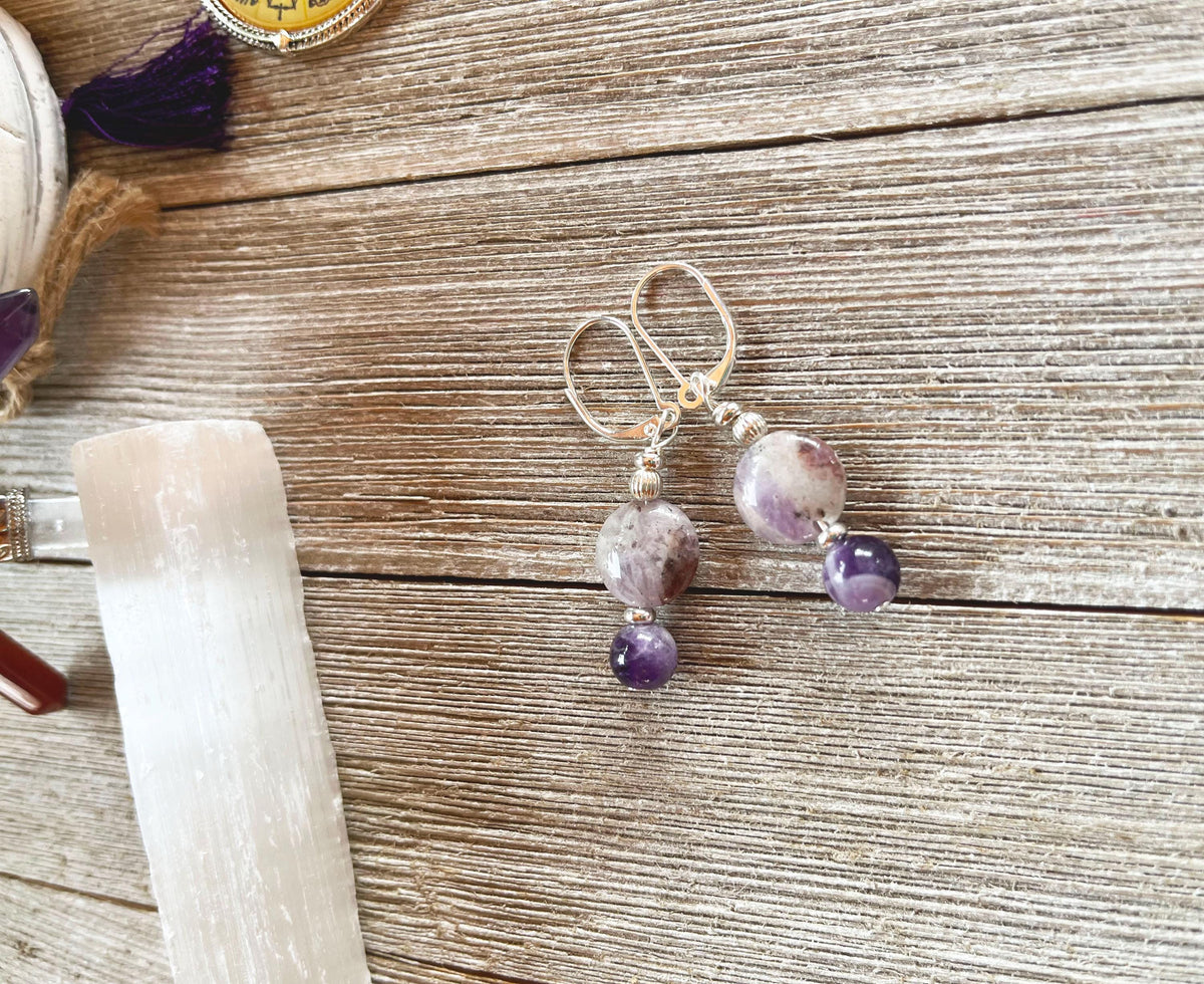 Handmade Sacred Geometry Earrings for Spiritual Enlightenment and Tranquility Amethyst, featuring two round marbled purple and white beads on silver hooks—ideal for lovers of spiritual jewelry. Displayed on rustic wood.