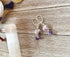 Handmade Sacred Geometry Earrings for Spiritual Enlightenment and Tranquility Amethyst, featuring two round marbled purple and white beads on silver hooks—ideal for lovers of spiritual jewelry. Displayed on rustic wood.