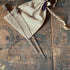 The Elegant Purple Glass Skewers for Charcuterie Boards come as a set of 2 sparkle toppers, ideal for party decor, displayed on a burlap drawstring pouch atop a rustic wooden surface with visible black lettering.