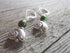Handmade Beach Lover Shell Earrings with color-changing beads and spiral shell-shaped charms rest on a rustic wooden surface—unique jewelry for beach lovers.