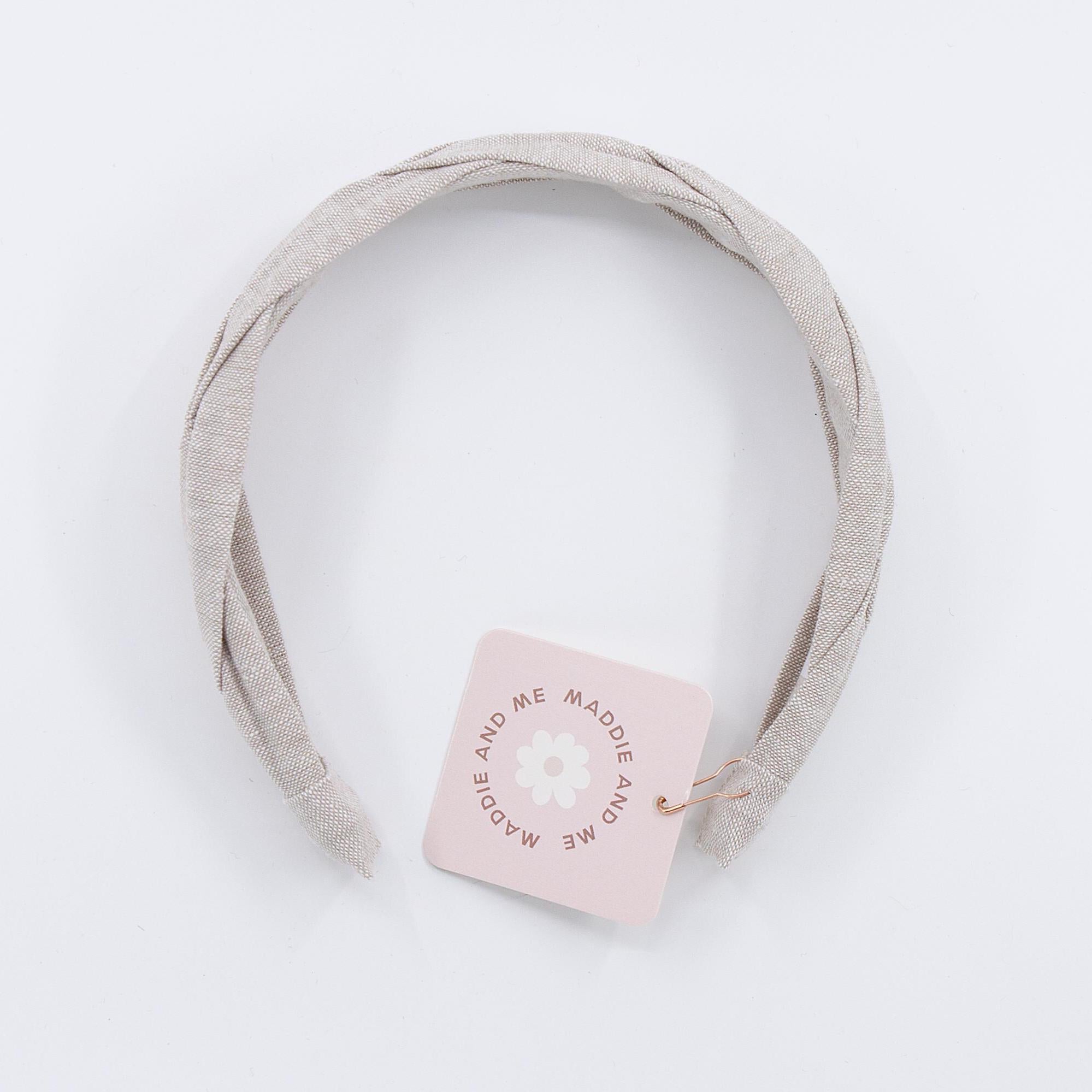 A light tan braided linen headband. The headband has a tag that says &amp;quot;MADDIE AND ME&amp;quot;.