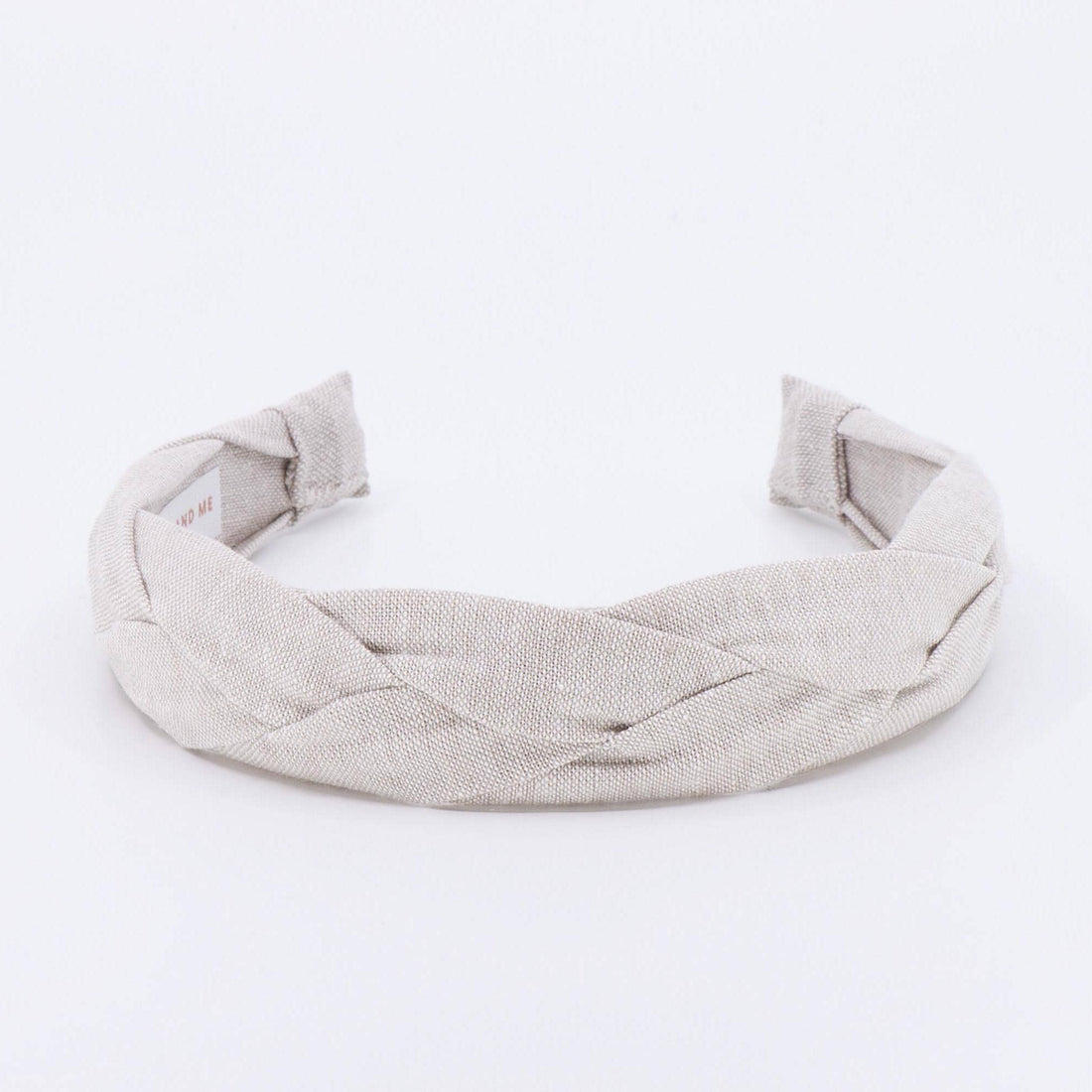 A light tan braided linen headband.