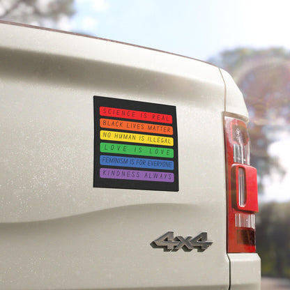 Square bumper magnet in rainbow blocks reading “Science is Real, Black Lives Matter, No Human is Illegal, Love is Love, Feminism is for Everyone, Kindness Always”