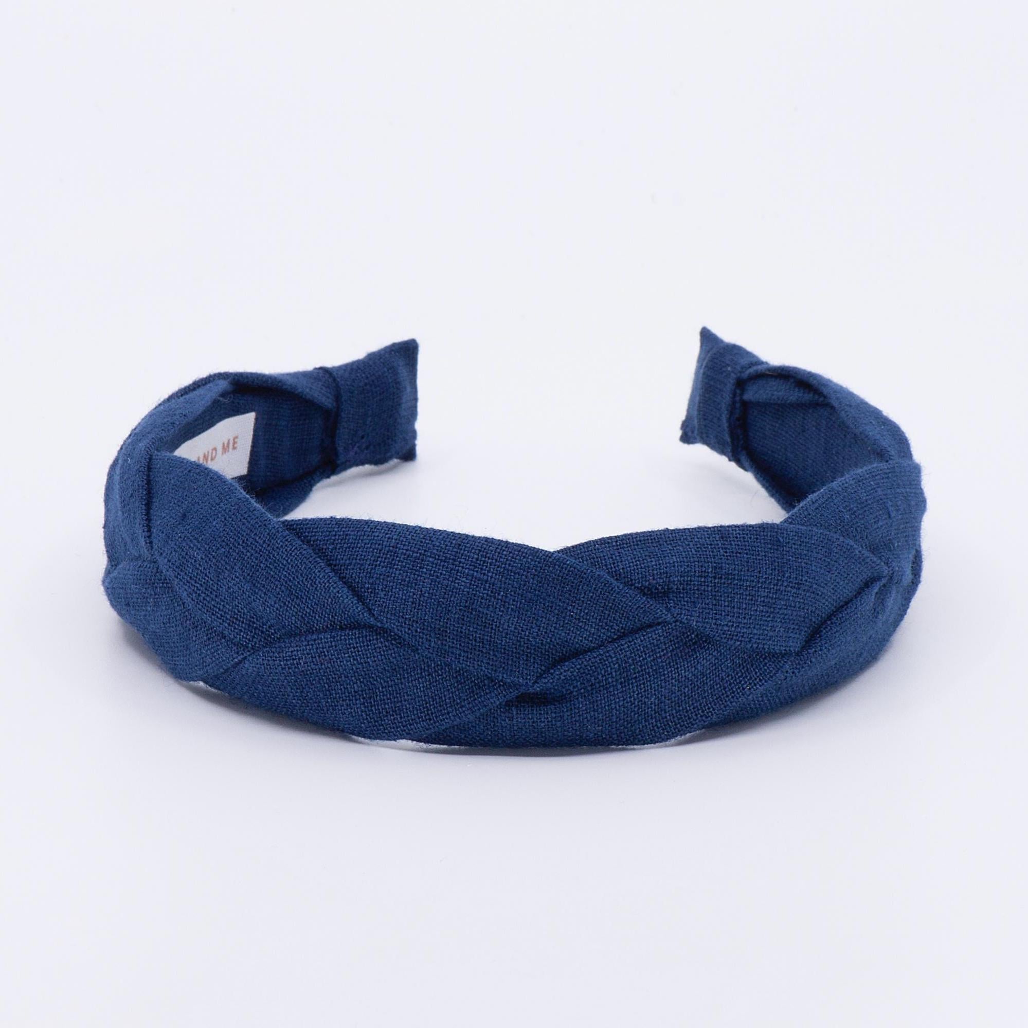 May include: A dark navy blue braided headband made of linen fabric.