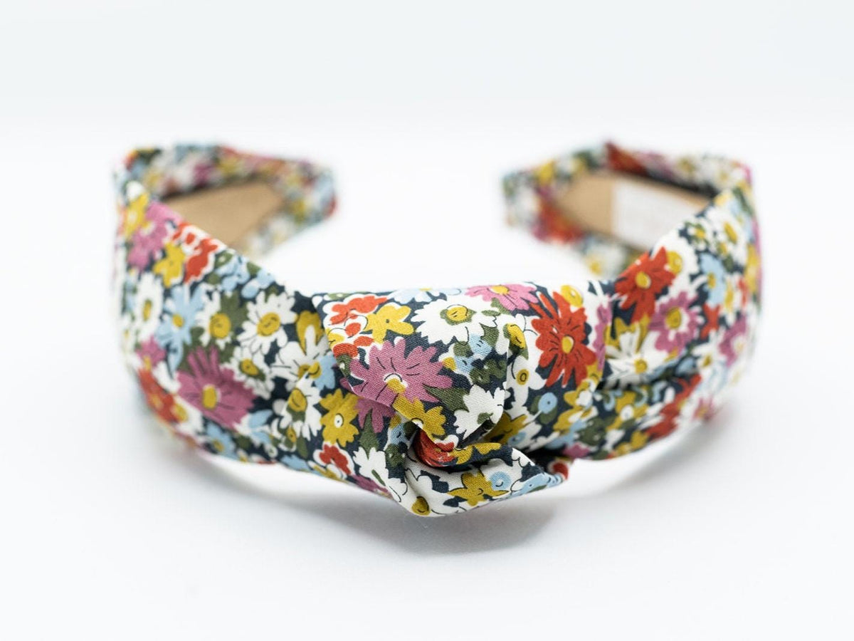 May include: A floral headband with a knotted design.
