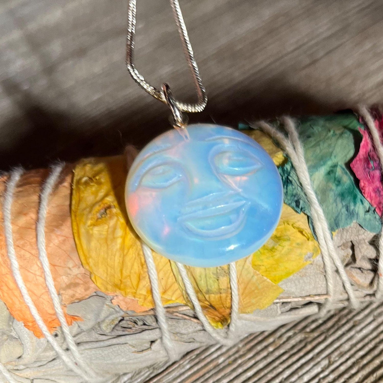 The Full Moon Opalescent Necklace, a celestial-themed accessory for peace and quiet, features a blue opalescent pendant on a silver chain—making an unusual and playful gift.