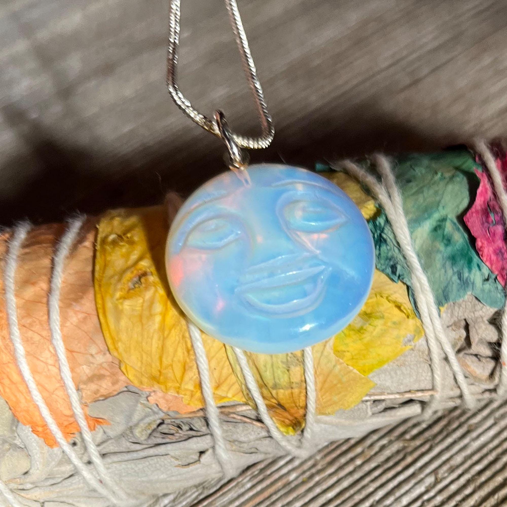 The Full Moon Opalescent Necklace, a celestial-themed accessory for peace and quiet, features a blue opalescent pendant on a silver chain—making an unusual and playful gift.