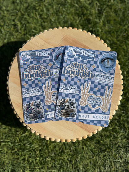 May include: Two stickers with a blue and white checkered background. The stickers have text that says &amp;quot;MORALLY GRAY&amp;quot;, &amp;quot;stay bookish&amp;quot;, &amp;quot;Good Girls Read Bad Books&amp;quot;, and &amp;quot;SMUT READER&amp;quot;. Other graphics include a skull, a skeleton hand, and an eye.