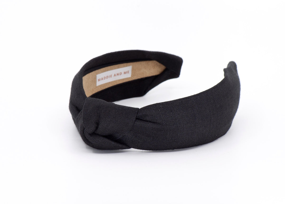 May include: A black knotted headband made of linen fabric. The headband has a label that says &amp;quot;MADDIE AND ME&amp;quot;.
