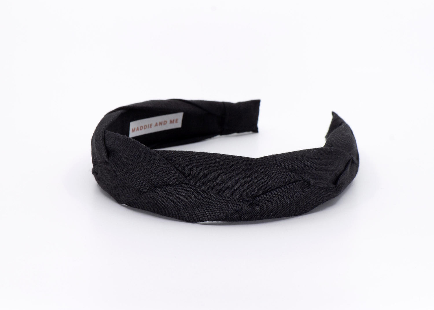May include: A black braided headband made of fabric.
