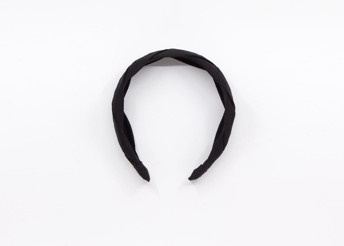 May include: A black braided headband made of fabric.