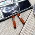 Red Jasper Heart Earrings – Zen Natural Stone Jewelry: Handmade earrings with silver hooks, orange rectangular beads, heart-shaped and silver accents—beautifully displayed on wood beside a mirrored tile for grounding energy and charm.