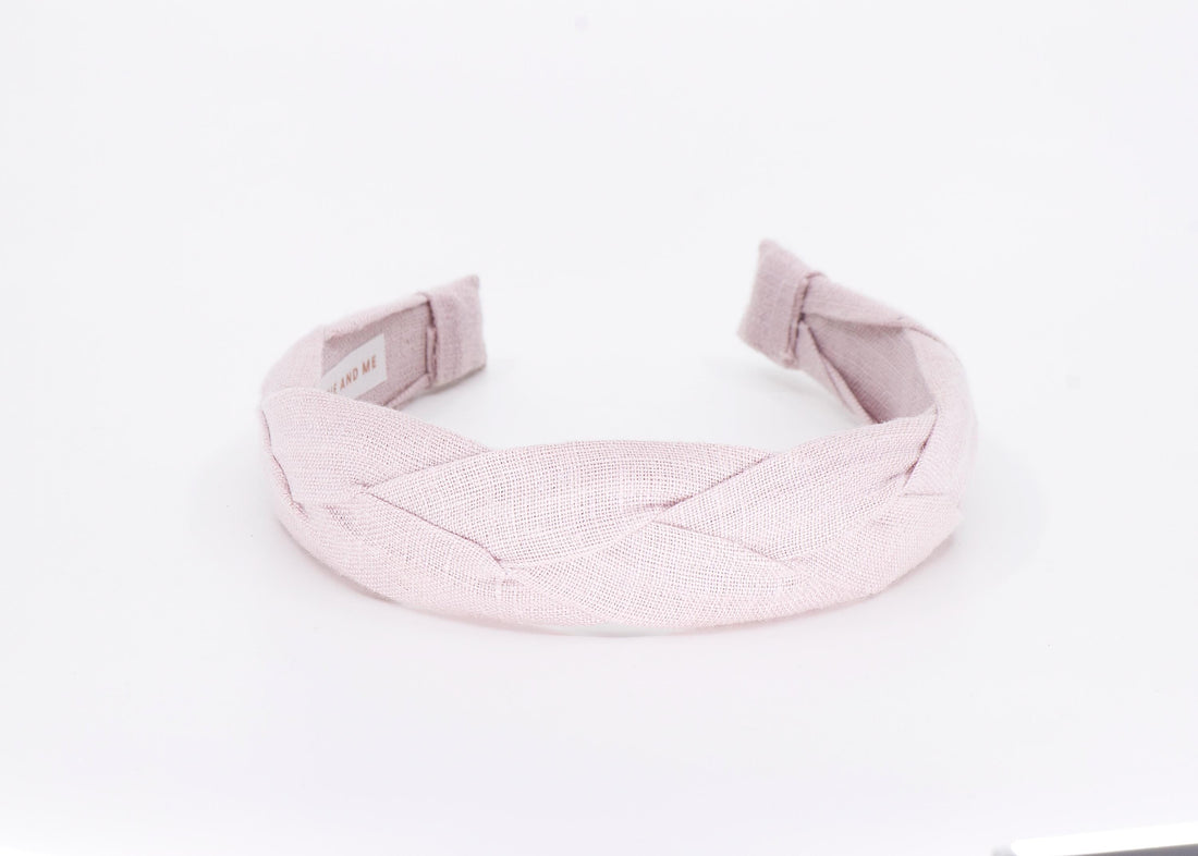 A light pink braided linen headband.