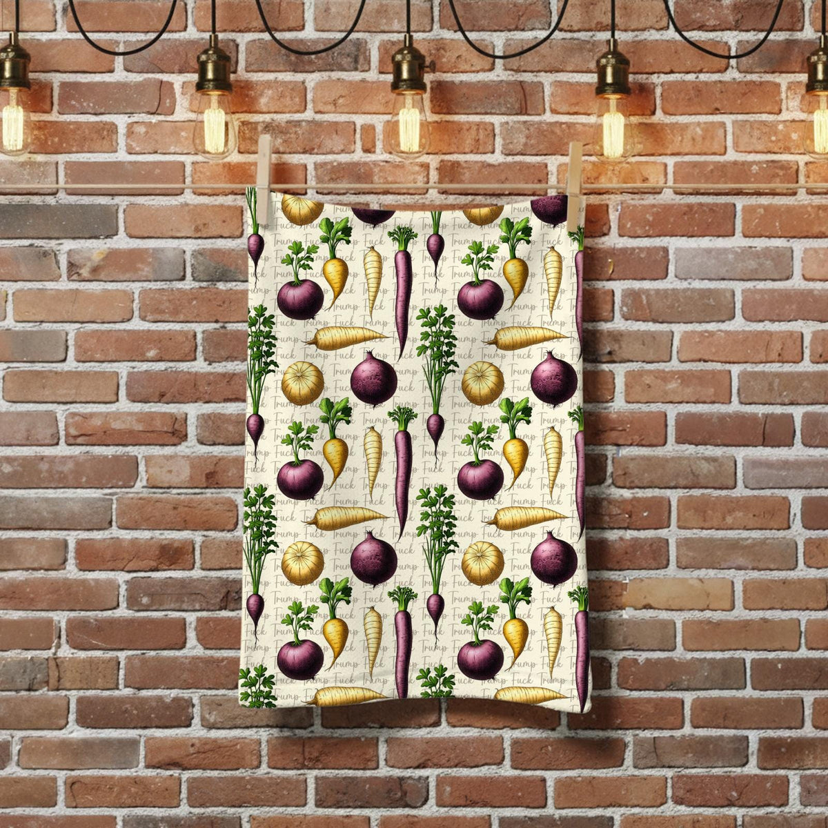 Kitchen towel with a repeating pattern of carrots, turnips, and other vegetables.
