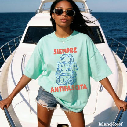 Woman in mint green t-shirt with snake and &amp;quot;SIEMPRE ANTIFASCISTA&amp;quot; graphic, on a boat.