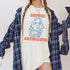 Cream t-shirt with red text "SIEMPRE ANTIFASCISTA" and three-headed dog graphic.