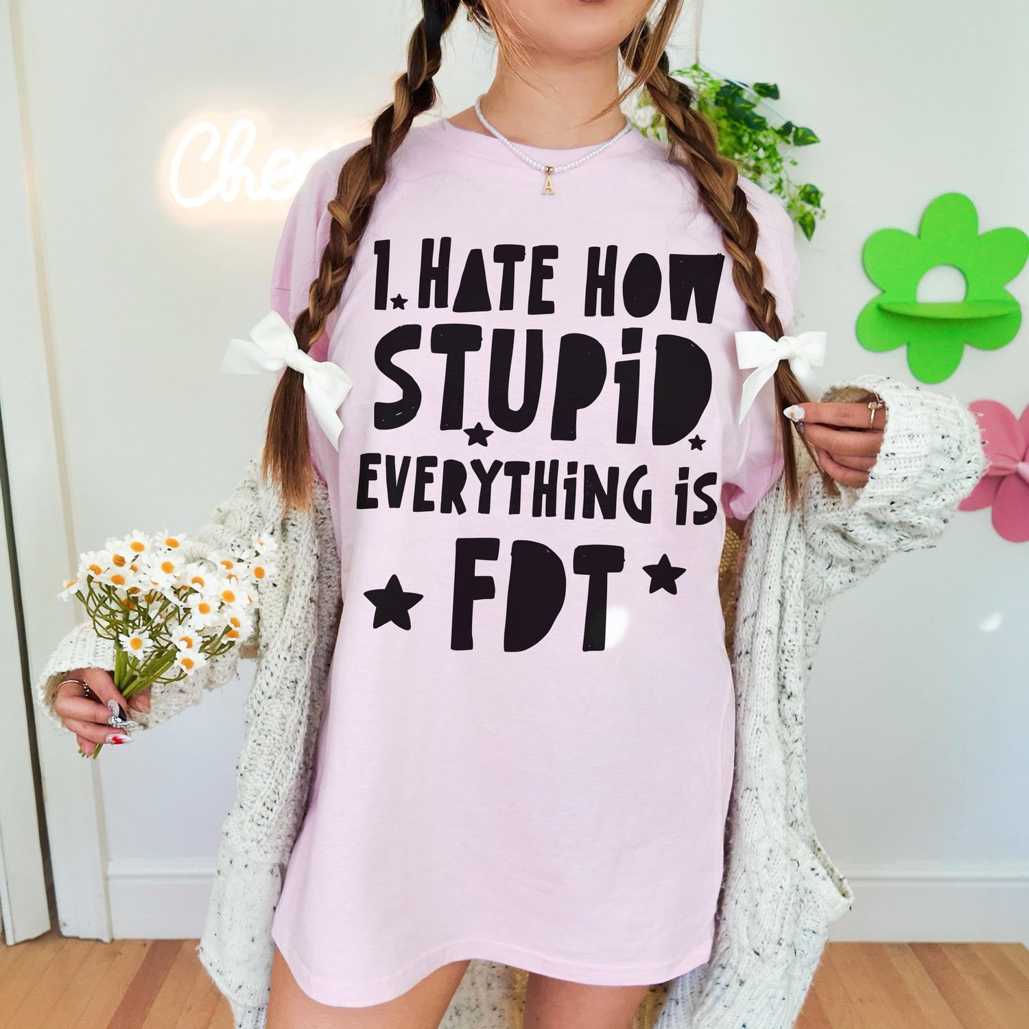 Pink t-shirt with &amp;quot;I hate how stupid everything is&amp;quot; text, held by a person with pigtails.