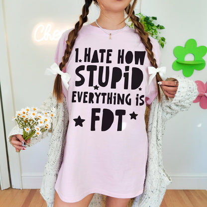 Pink t-shirt with &amp;quot;I hate how stupid everything is&amp;quot; text, held by a person with pigtails.