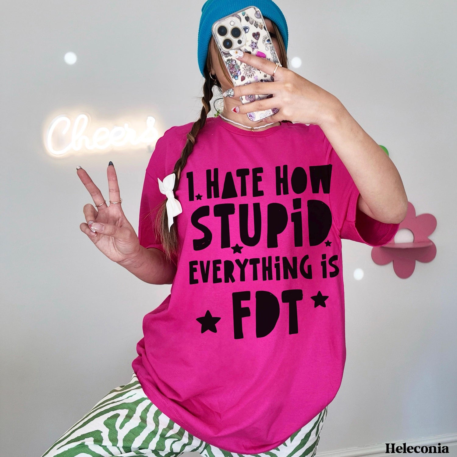Woman in pink t-shirt that reads &amp;quot;I HATE HOW STUPID EVERYTHING IS FDT&amp;quot; flashes peace sign.