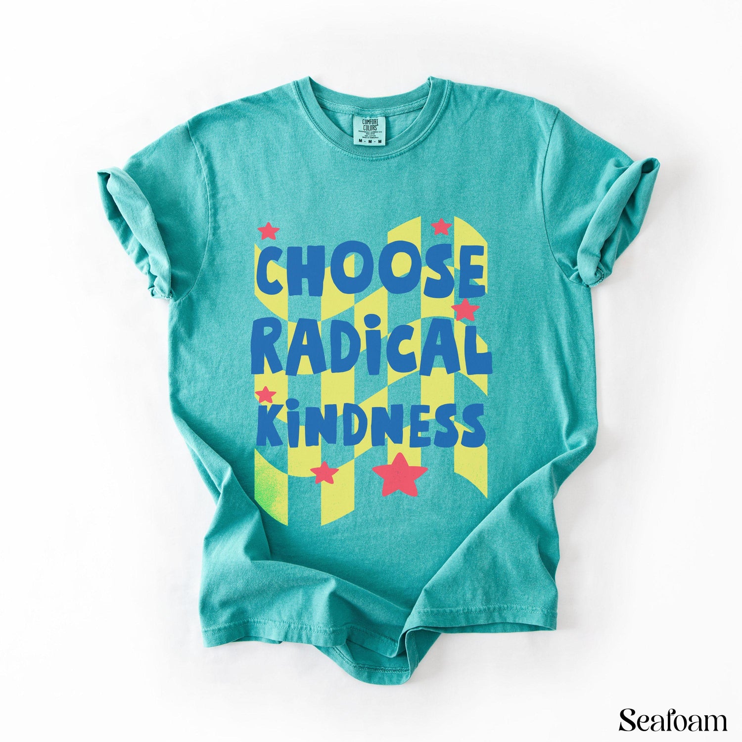Teal t-shirt with yellow and blue geometric pattern and &amp;quot;CHOOSE RADICAL KINDNESS&amp;quot; text.