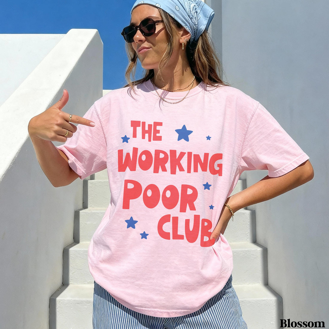 Woman wearing a pink t-shirt with red text and blue stars, &amp;quot;THE WORKING POOR CLUB&amp;quot;.