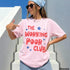 Woman wearing a pink t-shirt with red text and blue stars, "THE WORKING POOR CLUB".