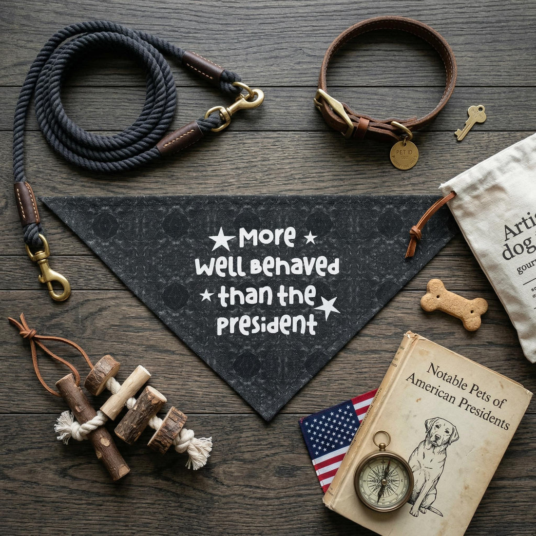 Dark bandana with &amp;quot;More well Behaved than the President&amp;quot; text, dog collar, rope, toy, and book.