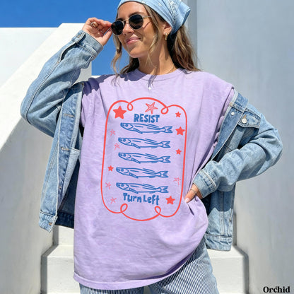 Purple t-shirt with red outline and illustration of five fish and text &amp;quot;RESIST TURN LEFT&amp;quot;.