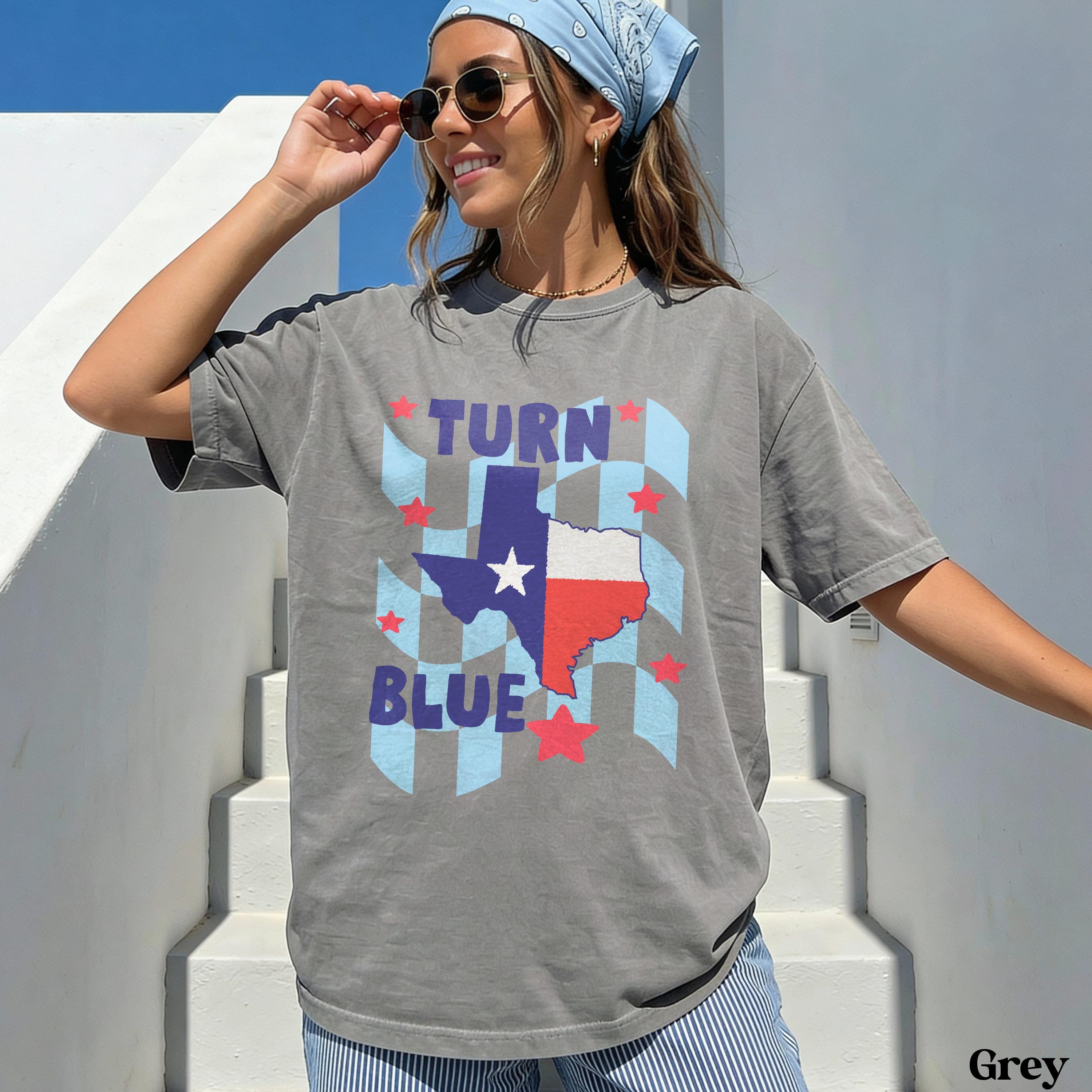 Woman wearing gray t-shirt with Texas flag and blue checkered design.