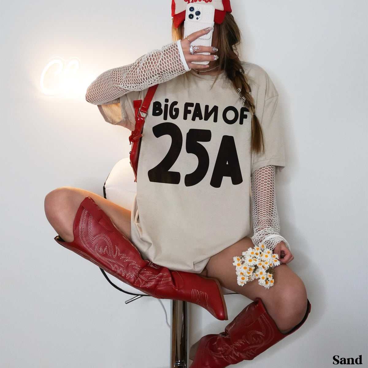 Woman in &amp;quot;BIG FAN OF 25A&amp;quot; t-shirt, red boots, and white fishnet sleeves.